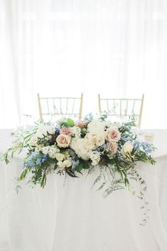 a table with flowers and greenery on it