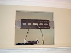 a tv remote control sitting on top of a shelf