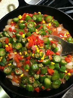 a skillet filled with vegetables on top of a stove