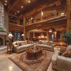 a living room filled with furniture and a fire place in the middle of an open floor plan