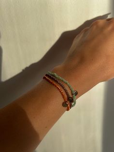 a woman's arm with two bracelets on it, one is green and the other is red