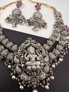 Goddess Lakshmi Silver Replica Short Necklace with matching EarringsColor : SilverSize : Necklace Length : Approx 18 Inches; Earrings Length : 2.75 InchesStones : AD Green Red Stone Antique Necklace Victorian, Necklace Traditional, Traditional Necklace, Real Pearl Necklace, Ethnic Necklaces, Traditional Earrings, Goddess Lakshmi, Kundan Necklaces, Oxidised Jewellery