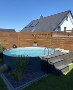 an above ground swimming pool with steps leading up to it and a wooden fence in the background