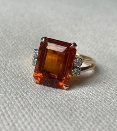 Such a wonderful step cut citrine ring 🧡 A classic design with a large dark orange citrine, which is is usually referred to as Madeira citrine. Flanked by four brilliant cut diamonds and set in a 14 karat yellow gold split shank. Note the lovely detail of the scroll work in the mount. The step cut Madeira citrine is ca. 9.75 ct.  measurements: 20.90 x 10.07 x 7.00 mm. Provenance: probably Germany or the Netherlands. Condition: this ring is in good condition except for a small chip missing at on Classic Orange Topaz Ring With Prong Setting, Classic Orange Diamond Ring, Classic Orange Topaz Ring For Anniversary, Formal Orange Topaz Ring With Diamond, Formal Orange Topaz Ring With Center Stone, Formal Orange Diamond Ring, Diamond Vintage Ring, Orange Citrine, Scroll Work