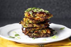 a stack of food sitting on top of a white plate next to a yellow napkin