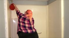 a woman with pink hair is holding a red frisbee in her hand while standing on the toilet