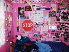 a bedroom with pink walls and lots of pictures on the wall, including a stop sign