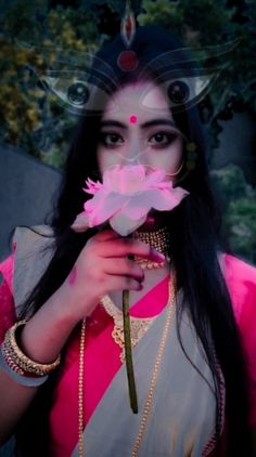 a woman with long black hair holding a flower