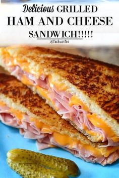 a grilled ham and cheese sandwich with pickles on the side is shown in this image