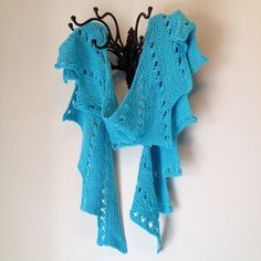 a blue scarf hanging from a hook on a wall