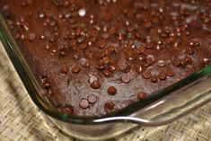 a chocolate cake in a glass dish on a table