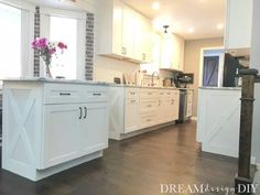 a kitchen with white cabinets and wooden floors