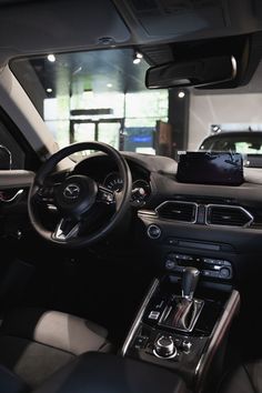 the interior of a car with black leather seats and dashboard controls, including steering wheel