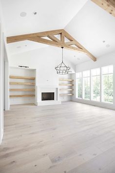 an empty living room with white walls and wood beams