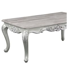 a white wooden table with ornate carvings on the top and bottom edge, against a white background