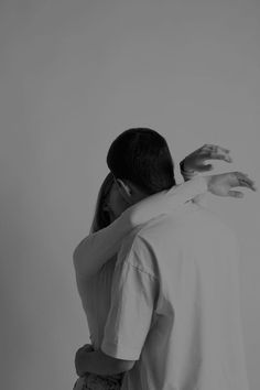 a man and woman embracing each other in black and white