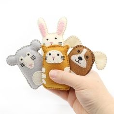 three small stuffed animals are held in their hands