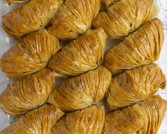 there are many croissants wrapped in paper on top of a tablecloth