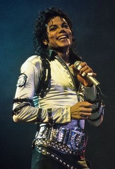 michael jackson performing on stage with microphone in his hand and studded belt around his waist