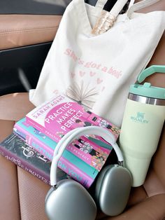 books, headphones and a tote bag sitting in the back seat of a car