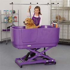 a woman holding a dog in a purple tub