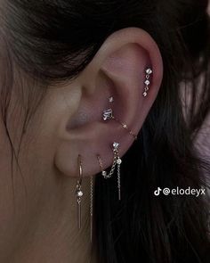 a woman's ear with three different piercings on the top and bottom of her ear