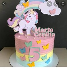 a pink and yellow cake with a unicorn on it's top that says 5