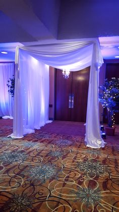 a room decorated with white drapes and flowers