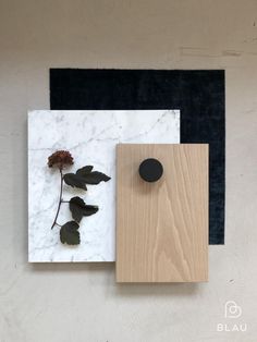 two pieces of wood and white marble with black knobs on the wall next to each other