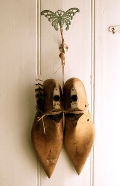 two wooden shoes hanging on a white door