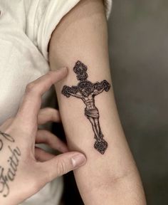 a person with a cross tattoo on their arm