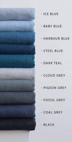 a stack of folded blue and grey linens on top of each other in different colors