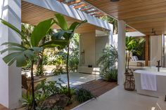 the inside of a house that has plants and trees on the outside side of it