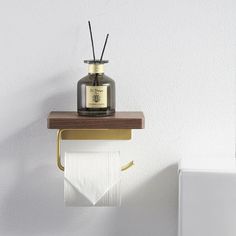 a white toilet sitting next to a wooden shelf with a candle on top of it