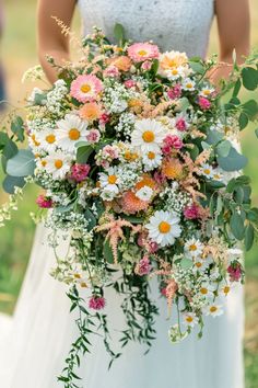 a bride holding a bouquet of flowers in her hands