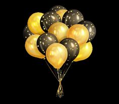 a bunch of black and gold balloons floating in the air