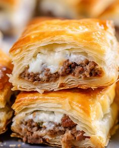 three pieces of meat and cheese pastry stacked on top of each other, with one piece cut in half