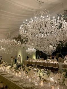 a wedding reception with chandeliers and white flowers