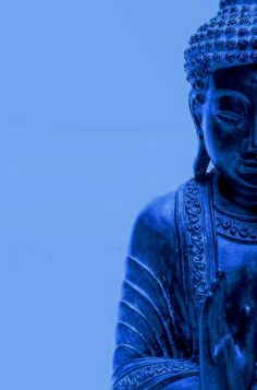 a blue buddha statue with his hands clasped in front of him, against a blue background