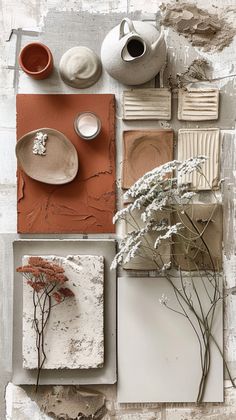 an assortment of pottery and flowers sitting on top of a piece of paper with paint chippings