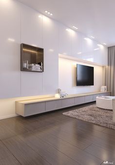 a living room with white walls and wooden flooring has a flat screen tv mounted on the wall