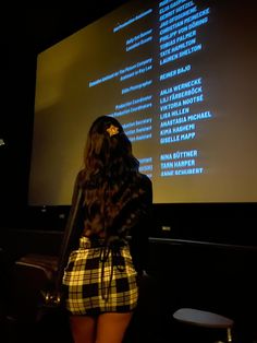 a woman standing in front of a projection screen