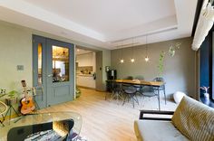 a living room filled with furniture and a glass table next to a doorway that leads into a kitchen