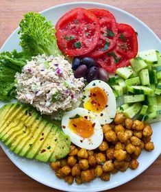 a white plate topped with vegetables and eggs