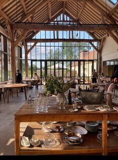 the inside of a restaurant with tables, chairs and plates on display in front of large windows