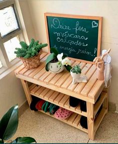 a potted plant sitting on top of a wooden shelf next to a chalkboard