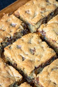 chocolate chip cookie bars sitting on top of a wooden cutting board