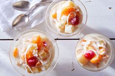 four desserts in glass bowls with fruit on top