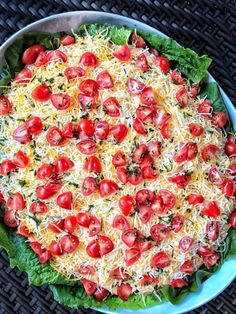 a pizza with cheese, tomatoes and lettuce in a pan on a table