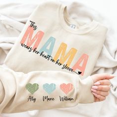 Mama Wear Her Heart On Her Sleeve, Mama Sweatshirt Custom Name On Sleeve, Mom Gift Shirt, Vintage Mother Day Sweatshirt Trendy Gift For Mom 📌This design will be made with DTF. IMPORTANT NOTE 👉Various factors such as your screen resolution, color settings, display type, lighting conditions during photoshoot, and the fact that each person sees colors differently, can all affect how the colors are displayed on the Internet. Consequently, actual colors may slightly vary HOW TO ORDER 👉Please check Mama Tshirt Ideas, Cricut Gifts For Mom, Cute Cotton T-shirt For Mother's Day, Mama Shirt With Name On Sleeve, Mama Valentine Shirt, Personalized Mother's Day T-shirt, Cute Mother's Day T-shirt With Custom Print, Sublimacion Ideas, Sweatshirt Trendy